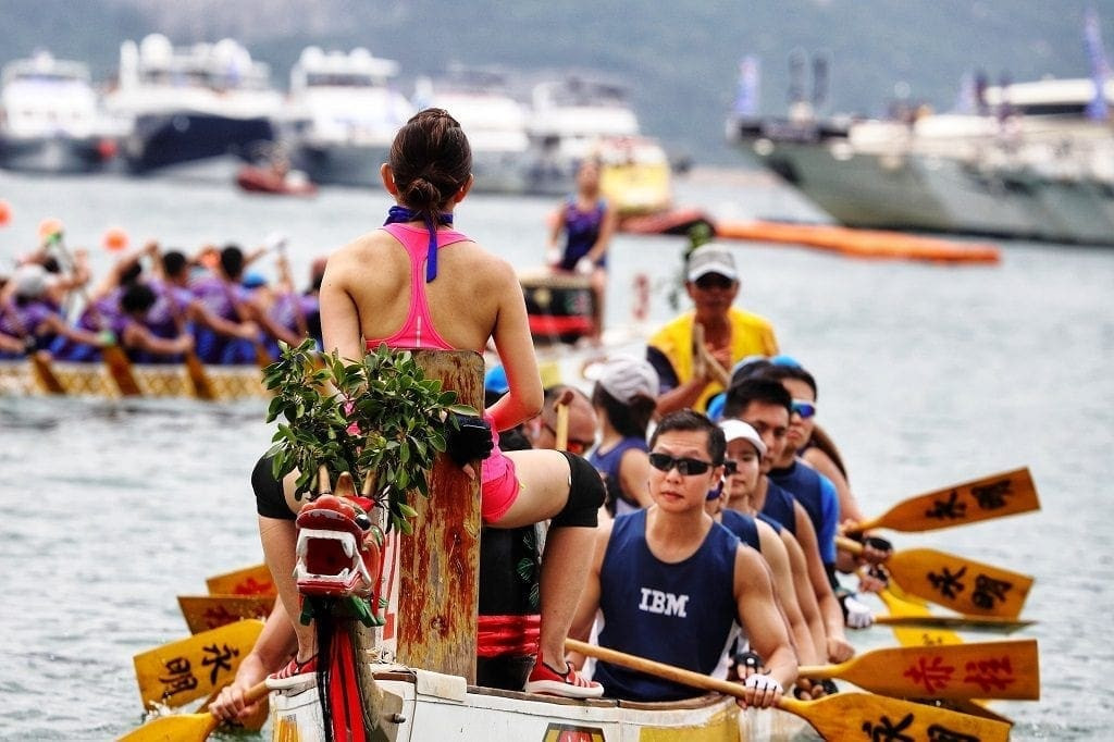 A crew of rowers competes to the beat of a drum